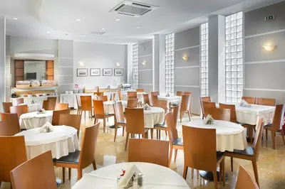 a dining room with white tables and chairs at Jason Inn in Athens