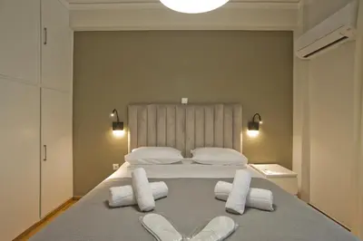 a bedroom with a bed with white towels and slippers at Fabi's Place Luxurious 2BR, Fully Renovated Apt in Athens