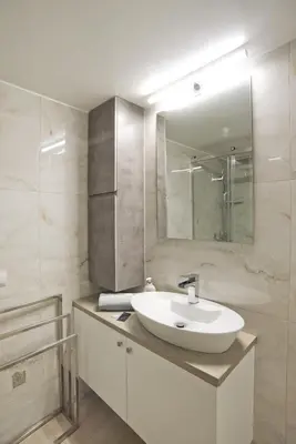 a white bathroom with a sink and a mirror at Fabi's Place Luxurious 2BR, Fully Renovated Apt in Athens