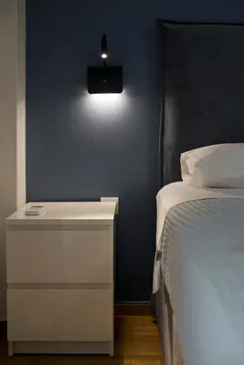 a bedroom with a bed and a nightstand with a light at Fabi's Place Luxurious 2BR, Fully Renovated Apt in Athens