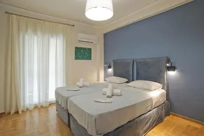 a bedroom with a large bed with white sheets at Fabi's Place Luxurious 2BR, Fully Renovated Apt in Athens