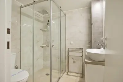a bathroom with a shower and a toilet and a sink at Fabi's Place Luxurious 2BR, Fully Renovated Apt in Athens