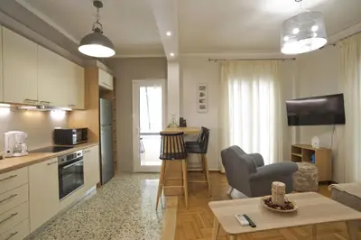 a kitchen and living room with a couch and a table at Fabi's Place Luxurious 2BR, Fully Renovated Apt in Athens