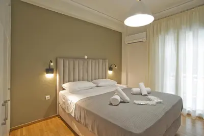 a bedroom with a large bed with towels on it at Fabi's Place Luxurious 2BR, Fully Renovated Apt in Athens
