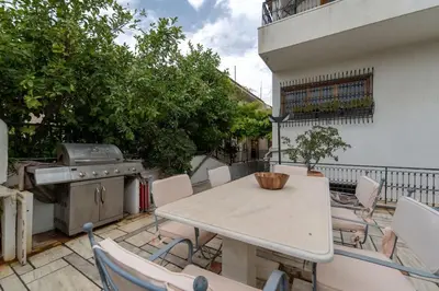 a table and chairs on a balcony with a grill at Private Entire Villa in Alimos in Athens