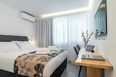 a bedroom with a bed and a desk with a laptop at Modern Studio in Syntagma - Walk to Acropolis in Athens