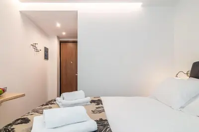 a bedroom with a white bed with towels on it at Modern Studio in Syntagma - Walk to Acropolis in Athens