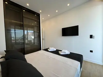 a bedroom with a bed and a flat screen tv at BlueMotion - CruiseNest 6Β in Piraeus