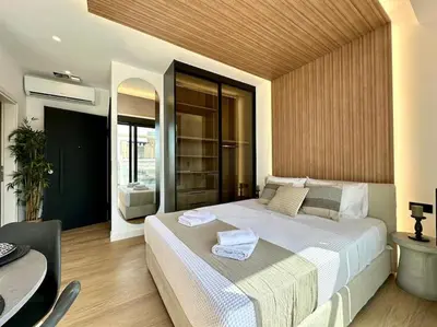 a bedroom with a large white bed and a table at BlueMotion - CruiseNest 6Α in Piraeus