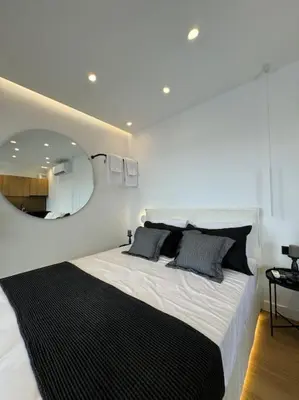 a bedroom with a large bed with a round mirror at BlueMotion - CruiseNest PortView in Piraeus