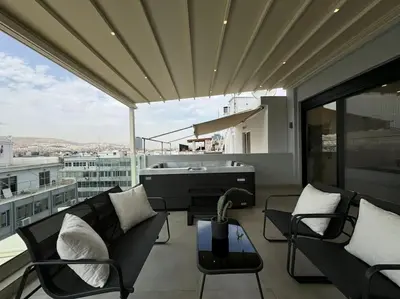 a balcony with chairs and a tub on a building at BlueMotion - CruiseNest PortView in Piraeus