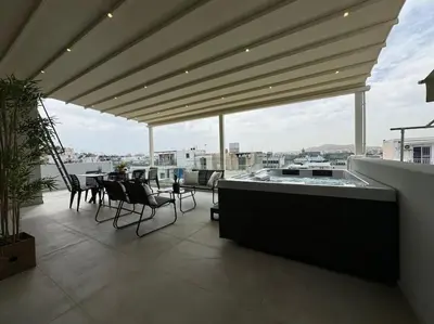 a patio with a table and chairs on a balcony at BlueMotion - CruiseNest PortView in Piraeus