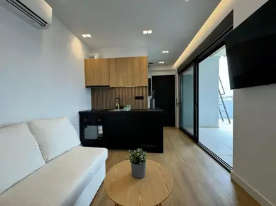 a living room with a white couch and a table at BlueMotion - CruiseNest PortView in Piraeus