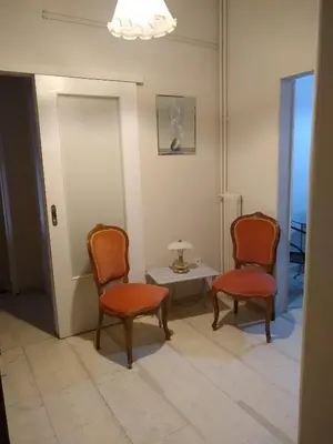 a room with two chairs and a table with a lamp at Classical beauty near Acropolis! in Athens