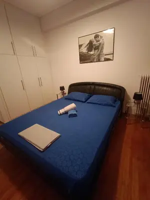 a bedroom with a bed with blue sheets and a folder at Classical beauty near Acropolis! in Athens