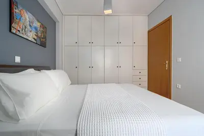 a bedroom with a large white bed with white cabinets at Luxurious Coastal Retreat in Central Glyfada in Athens