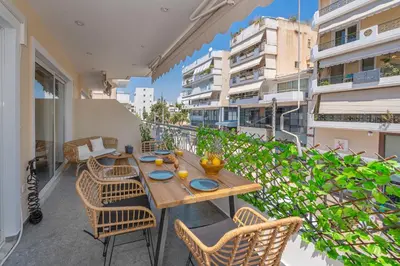 a patio with a table and chairs on a balcony at Luxurious Coastal Retreat in Central Glyfada in Athens