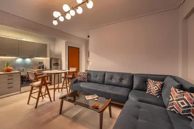 a living room with a blue couch and a table at Luxurious Coastal Retreat in Central Glyfada in Athens