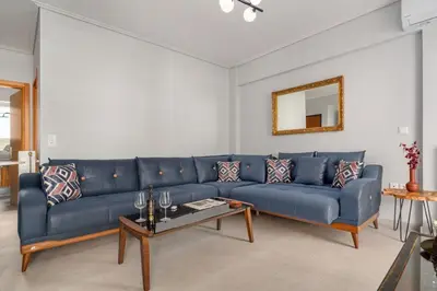 a blue couch in a living room with a table at Luxurious Coastal Retreat in Central Glyfada in Athens