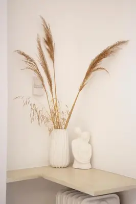 a white vase with a plant on a shelf at Alkisti in Athens