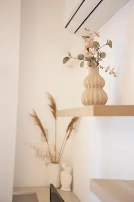 a vase with flowers on a shelf in a room at Alkisti in Athens