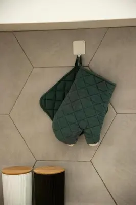 a green towel hanging from a counter next to two stools at Alkisti in Athens