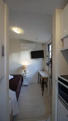 a small room with a bed and a desk and a table at Athens city center small penthouse in Athens