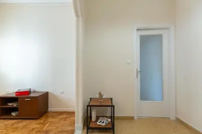 a white room with a table and a door at Olvios Attiki Metro in Athens