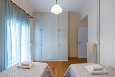 a bedroom with two beds and a large window at Olvios Attiki Metro in Athens