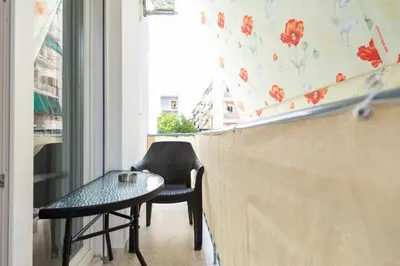 a table and two chairs in a room with a window at Olvios Attiki Metro in Athens