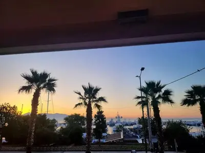 a group of palm trees with the sunset in the background at D-Marin Zea Marina 2 Bedroom in Piraeus