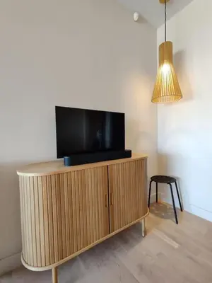 a television on top of a wooden cabinet with a lamp at D-Marin Zea Marina 2 Bedroom in Piraeus