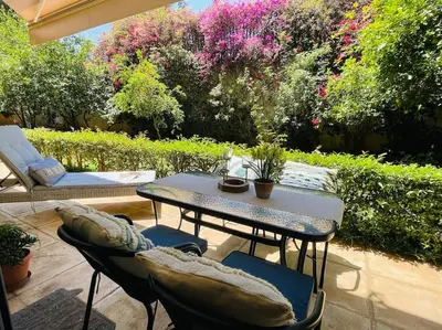 a patio with a table and chairs and flowers at \u8ff7\u4eba\u82b1\u56ed\u516c\u5bd3 Charming Garden in Athens