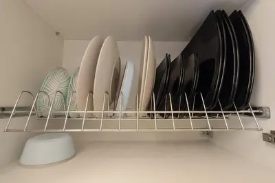 a shelf filled with plates and other dishes at \u8ff7\u4eba\u82b1\u56ed\u516c\u5bd3 Charming Garden in Athens