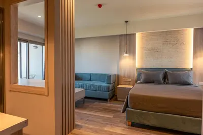 a bedroom with a bed and a blue couch at Wellnest Hotel in Athens