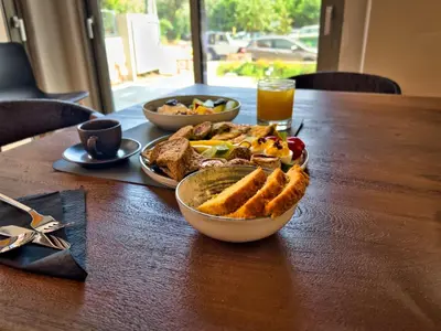 a table with two bowls of food and a glass of orange juice at Wellnest Hotel in Athens