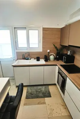 a kitchen with white cabinets and a sink and two windows at 110 Sqm 2BD Edem beach luxury apartment in Athens