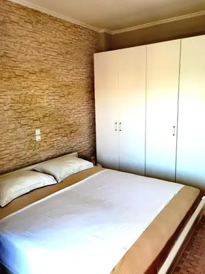 a bedroom with a large bed and a brick wall at 110 Sqm 2BD Edem beach luxury apartment in Athens
