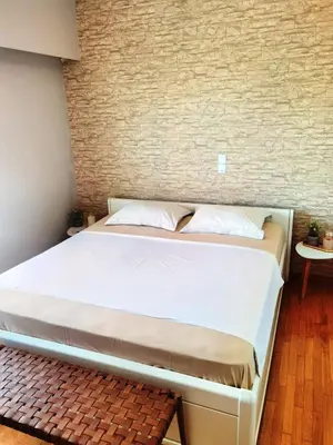 a bed in a room with a brick wall at 110 Sqm 2BD Edem beach luxury apartment in Athens
