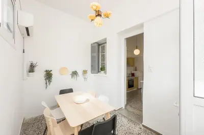 a dining room with a wooden table and chairs at Bright & Cozy House near Beach in Athens