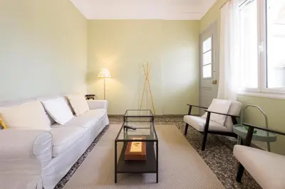 a living room with a white couch and a table at Bright & Cozy House near Beach in Athens