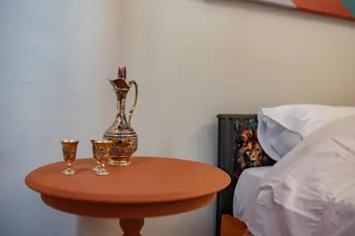 a table with two glasses on it next to a bed at Athenian Urban Art Apartment - Live Athenian Life in Athens