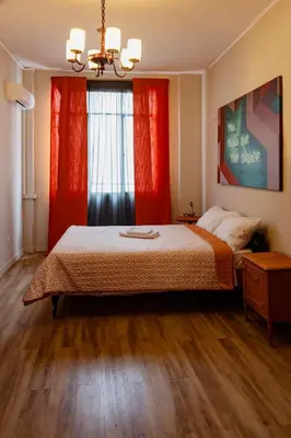a bedroom with a bed and a window with red curtains at Athenian Urban Art Apartment - Live Athenian Life in Athens