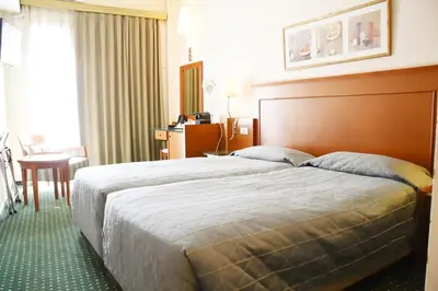 a hotel room with a large bed and a table at Adrian Hotel in Athens