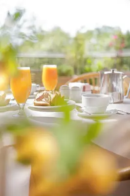 a table with a plate of food and two glasses of orange juice at Adrian Hotel in Athens