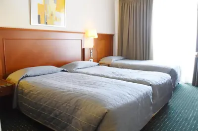 a hotel room with two beds and a window at Adrian Hotel in Athens