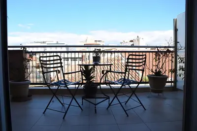a balcony with two chairs and a table with a view at Adrian Hotel in Athens