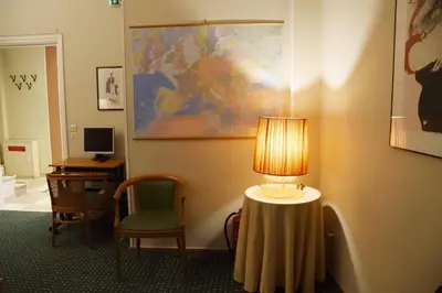 a room with a lamp and a chair and a desk at Adrian Hotel in Athens
