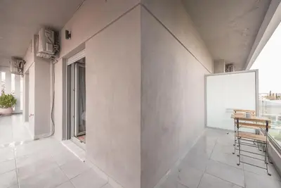 a room with a white wall with a table and chairs at Elegant & Spacious Apartment in Athens