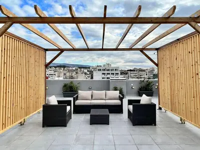 a patio with a couch and chairs on a roof at Elegant & Spacious Apartment in Athens